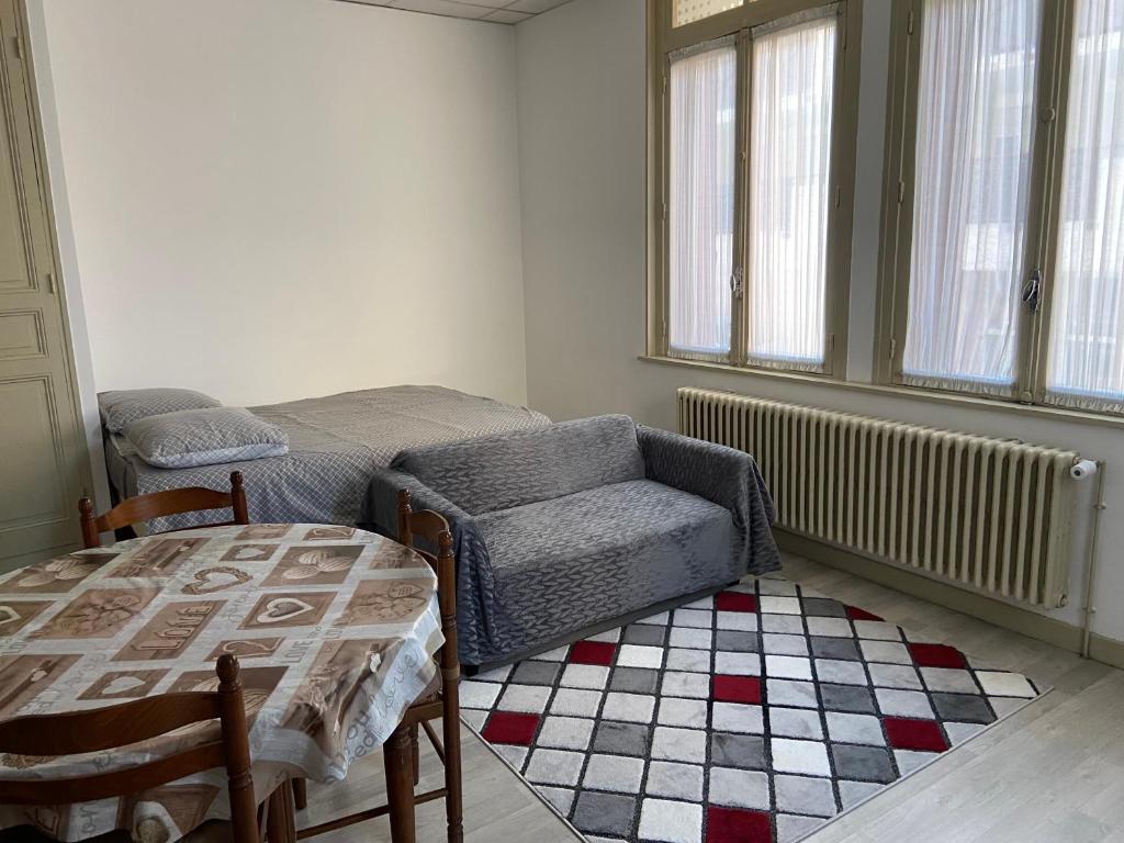 une chambre avec un lit, une chaise et une table dans l'établissement Studio centre-ville, à Digne-Les-Bains