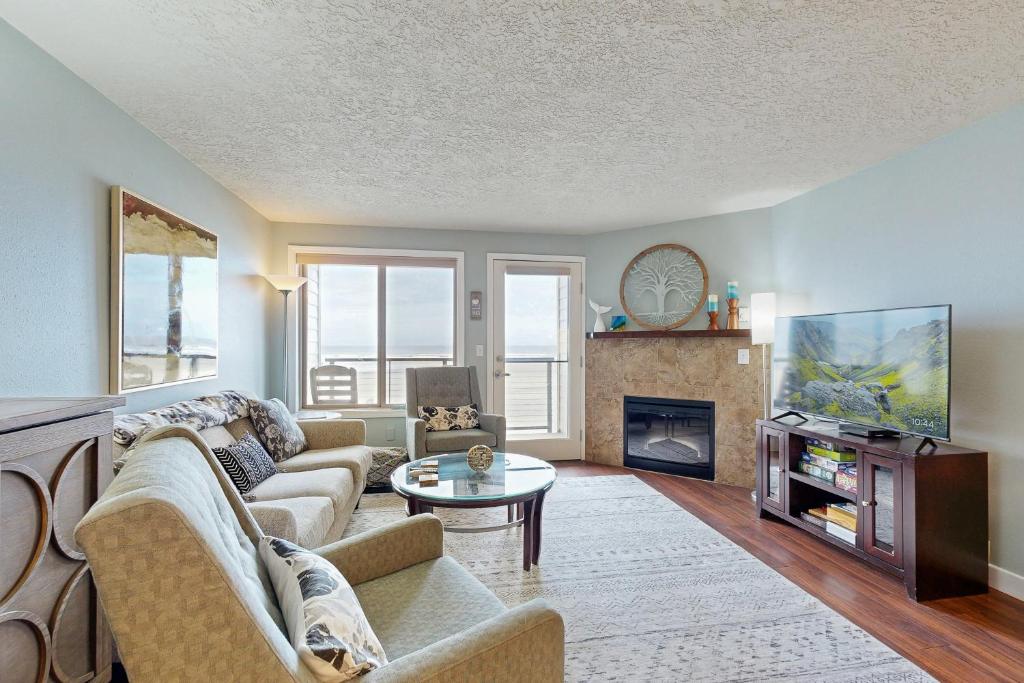 a living room with a couch and a fireplace at Ocean View Vacay in Rockaway Beach