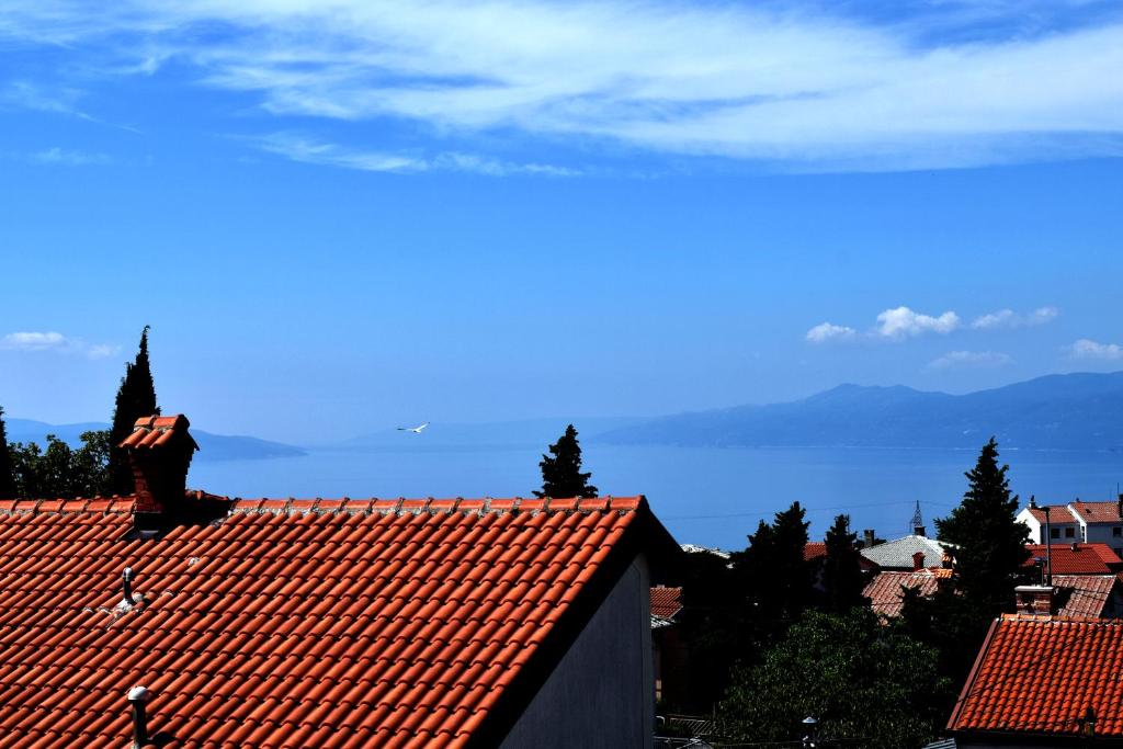 a person sitting on the roof of a building at Rijeka - Charming apartment with Sea View and Private Parking in Rijeka
