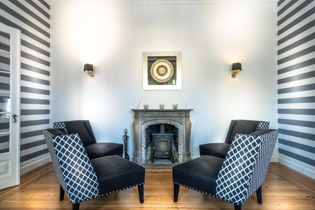a living room with two chairs and a fireplace at Villa Vasco da Gama in Cascais