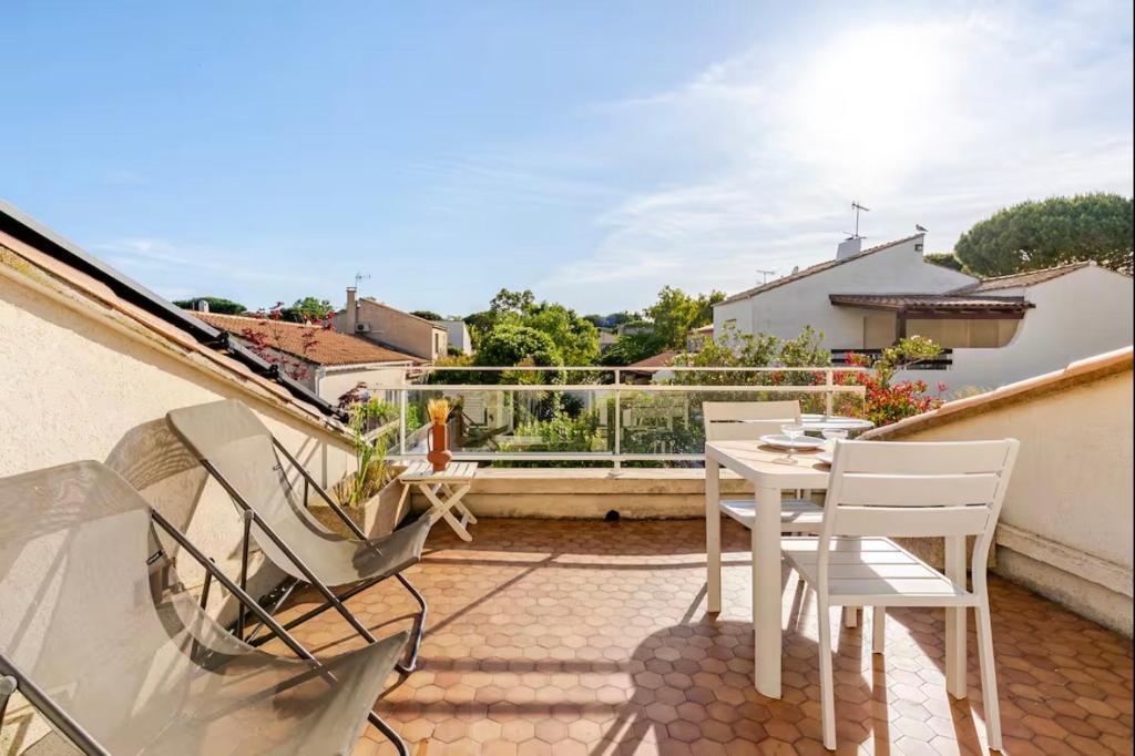 un patio avec une table et des chaises sur un balcon dans l'établissement Magnifique Appartement traversant avec vue sur le golf, à La Grande Motte
