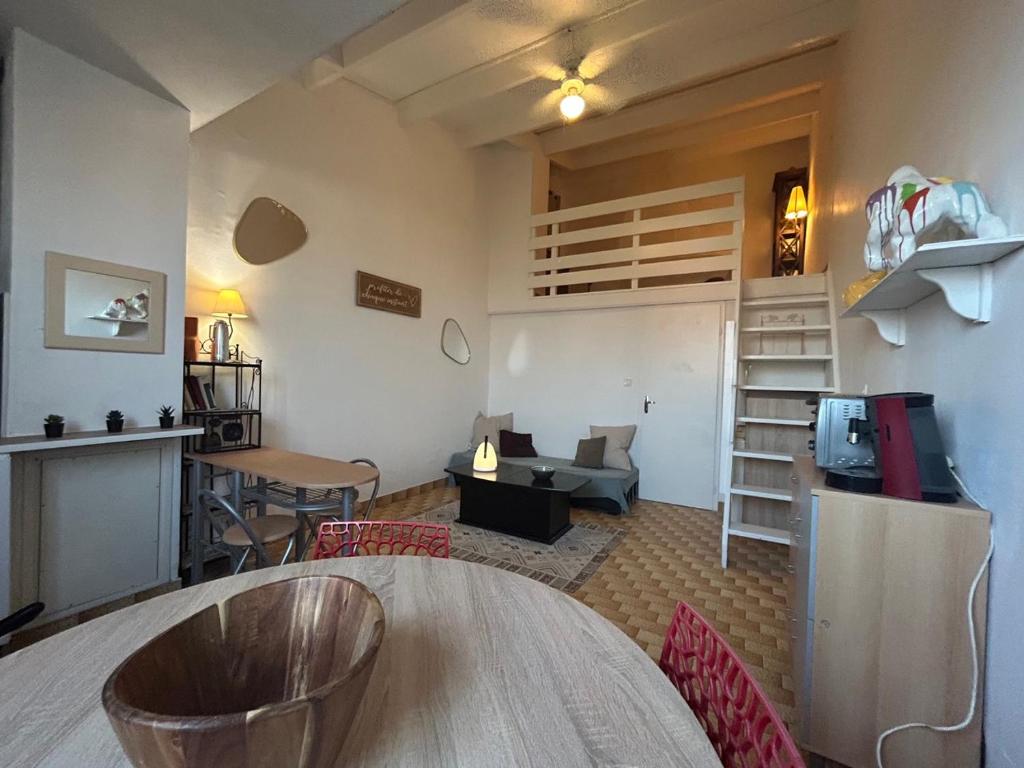 une chambre avec une table et des chaises ainsi qu'un salon dans l'établissement Sort tes tongs !!, au Cap d'Agde