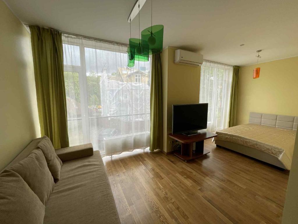 a living room with a bed and a television at RÜÜTLI City Center Apartment in Pärnu