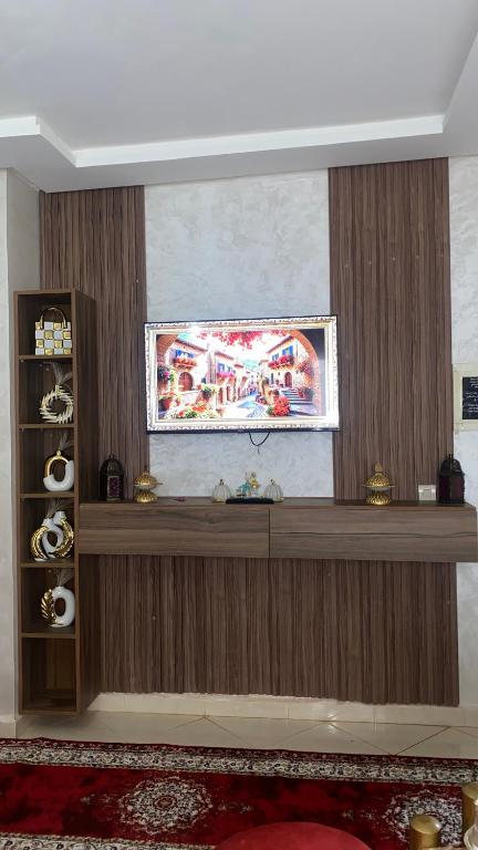 a living room with a wooden wall with a shelf at Appartement meublé en location nuitée in El Jadida