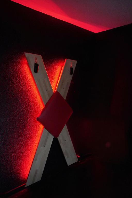 une lettre x dans une pièce avec une lumière rouge dans l'établissement L'instant Secret, à Saint-Pierre-du-Mont