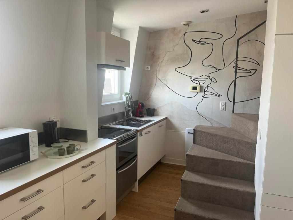 une petite cuisine avec un escalier et un escalier. dans l'établissement Lara Home, centre reims, à Reims