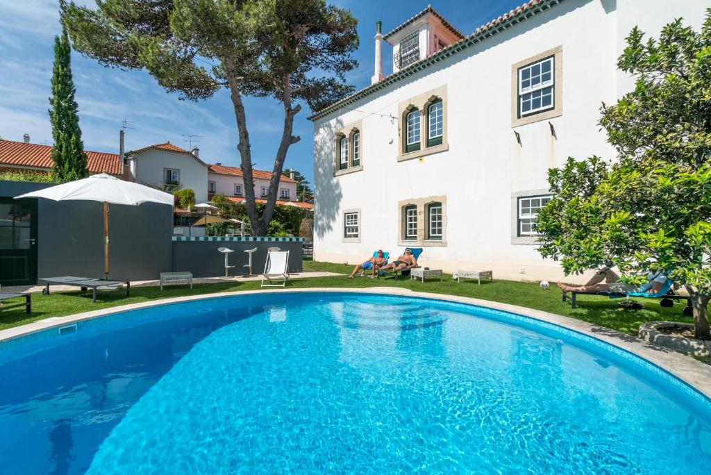 a swimming pool in front of a house at Villa Vasco da Gama in Cascais