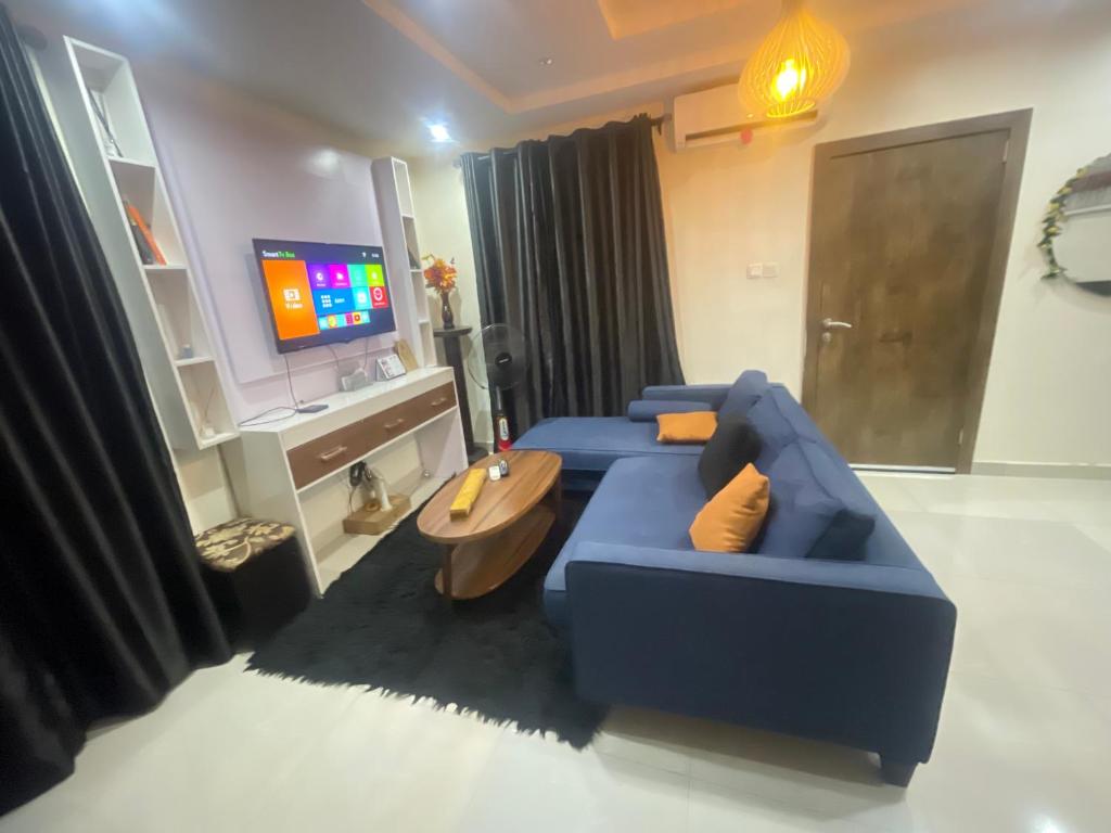 a living room with a blue couch and a tv at Spot1 in Ilado