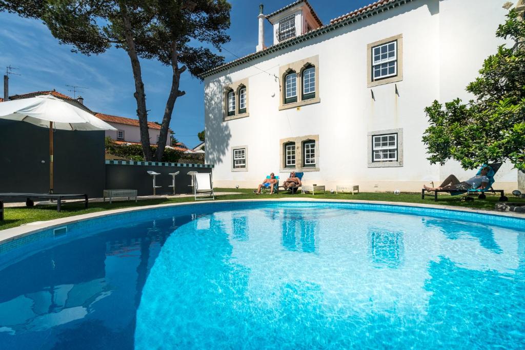 a swimming pool in front of a house at Villa Vasco da Gama in Cascais