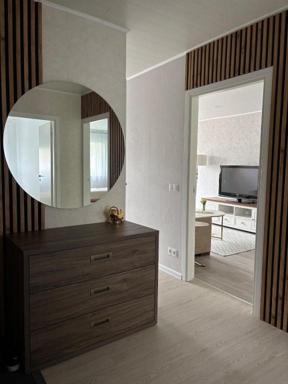 a living room with a dresser and a mirror at Cozy apartment in Haapsalu in Haapsalu