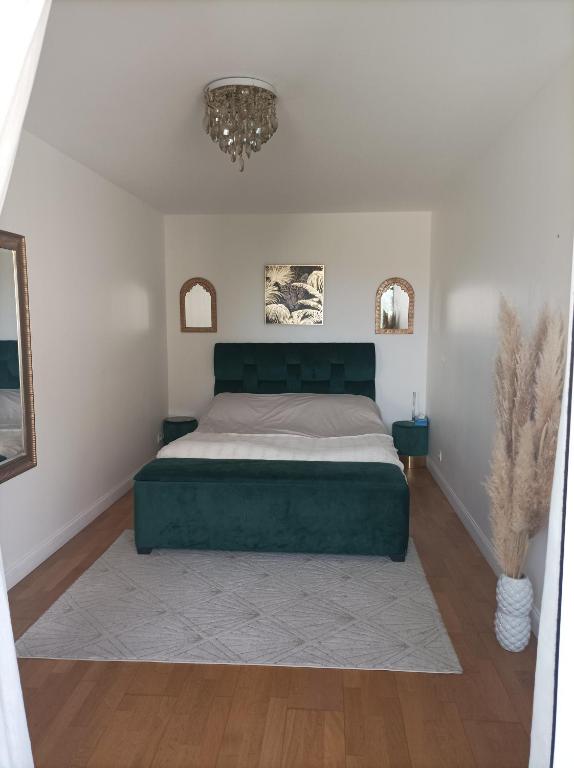 - une chambre avec un lit vert et un lustre dans l'établissement Bordeaux, à Bordeaux