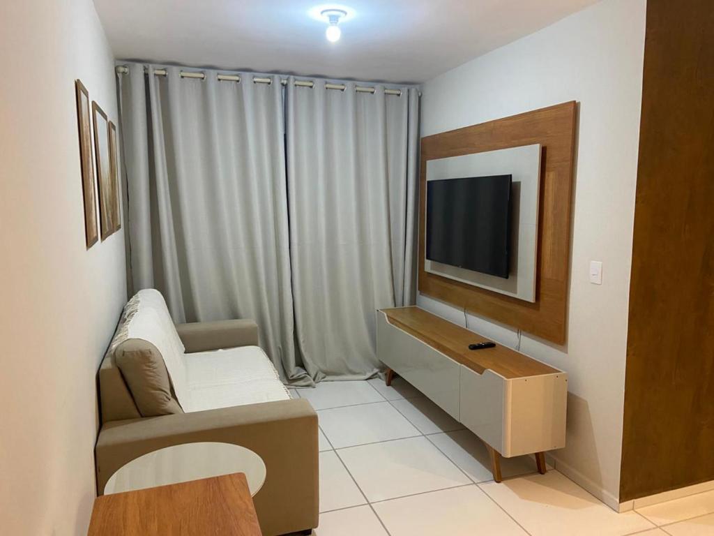 a living room with a tv and a couch and a chair at Apartamento em Garanhuns in Garanhuns