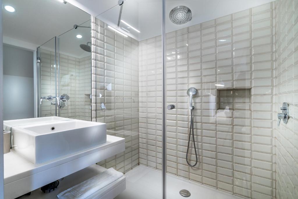 a white bathroom with a sink and a shower at Villa Vasco da Gama in Cascais