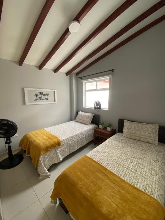 a bedroom with two beds and a window at Apartamento cerca al metro y viva envigado in Itagüí