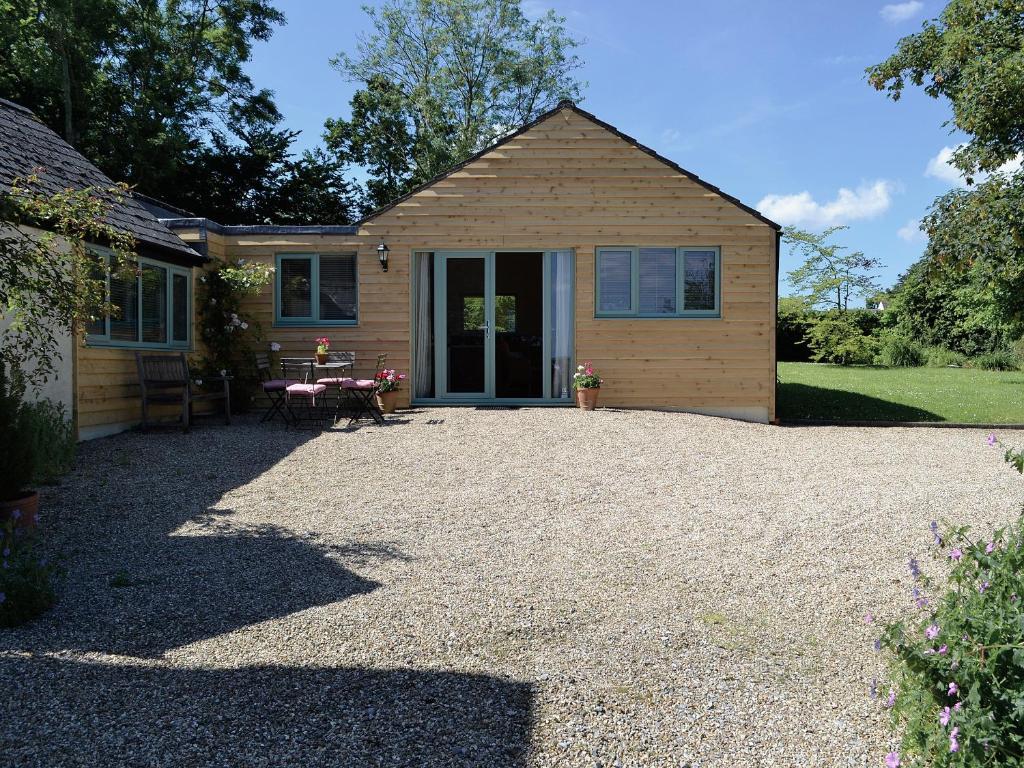 a house with a gravel driveway in front of it at Pottery Cottage in Broadway