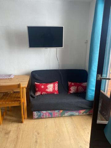 - un canapé bleu avec deux oreillers rouges dans l'établissement Appartement Puy Saint Vincent 1700, à Puy-Saint-Vincent