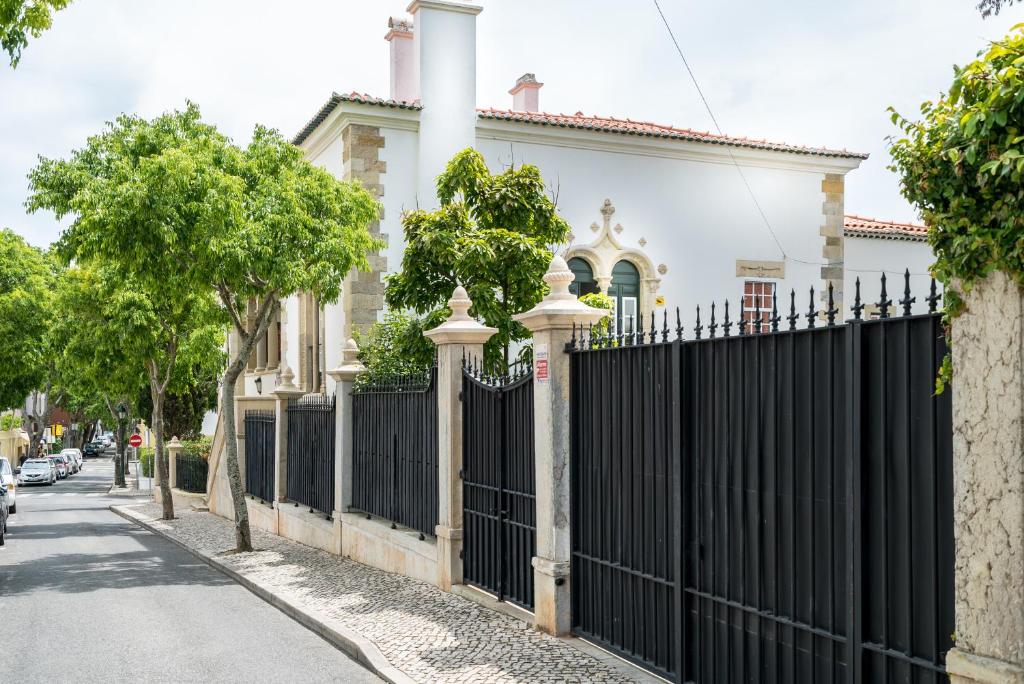 a black fence in front of a white house at Villa Vasco da Gama in Cascais
