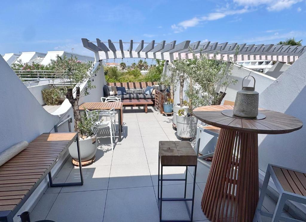 un patio avec une table et des chaises sur un balcon dans l'établissement Village naturiste, Port-Ambonne, appartement 42 m2, Le luxueux., au Cap d'Agde