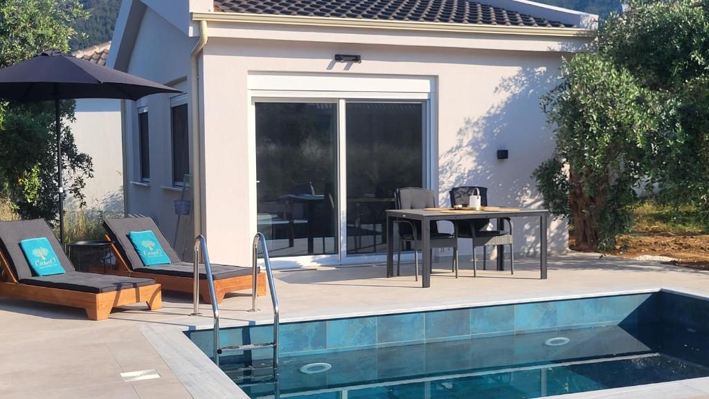 a pool with a table and chairs next to a house at Casa O' - House with private Pool in Limenas