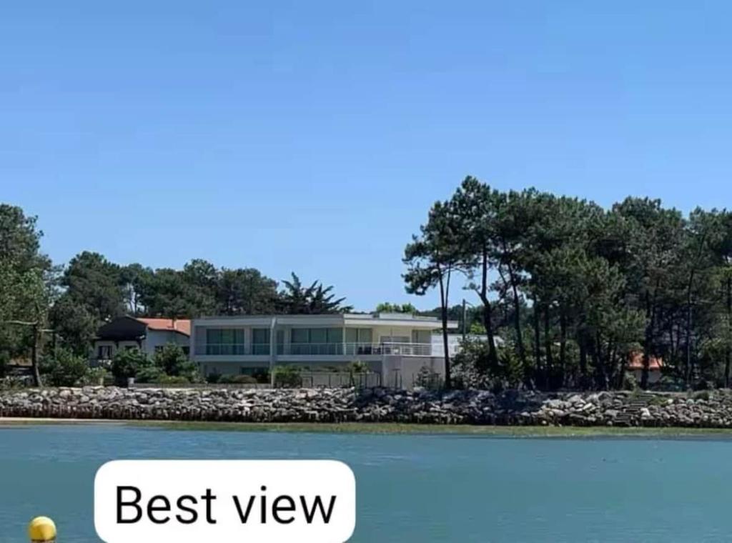 une maison au bord d'un lac avec les mots meilleure vue dans l'établissement Le Courant - 1 Chambre avec une vue imprenable, à Mimizan-Plage
