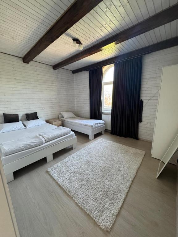 a bedroom with two beds and a rug at Садиба "Віталія" in Volovets