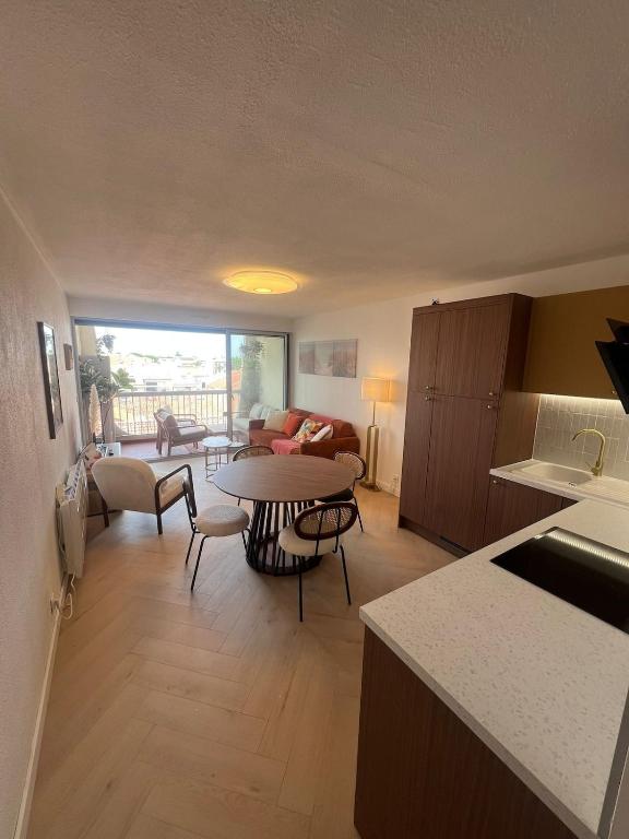 une cuisine et un salon avec une table et un canapé dans l'établissement Beautiful apartment with sea view, au Grau-du-Roi