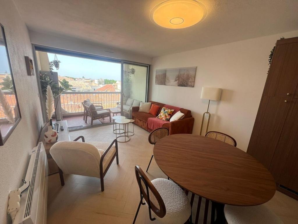 a living room with a table and a couch at Beautiful apartment with sea view in Le Grau-du-Roi
