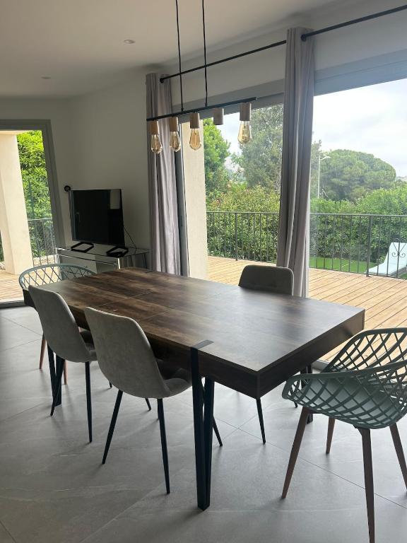 une salle à manger avec une table et des chaises en bois dans l'établissement House with pool, à Vallauris