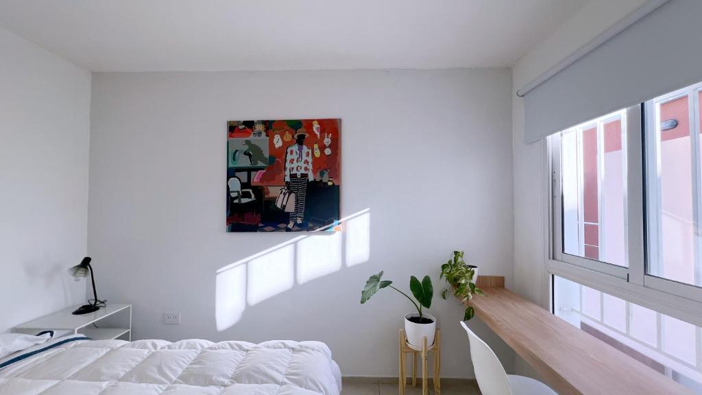 a white bedroom with a bed and a window at Temporario Sur, hasta 4 personas con 3 camas, General Roca in General Roca