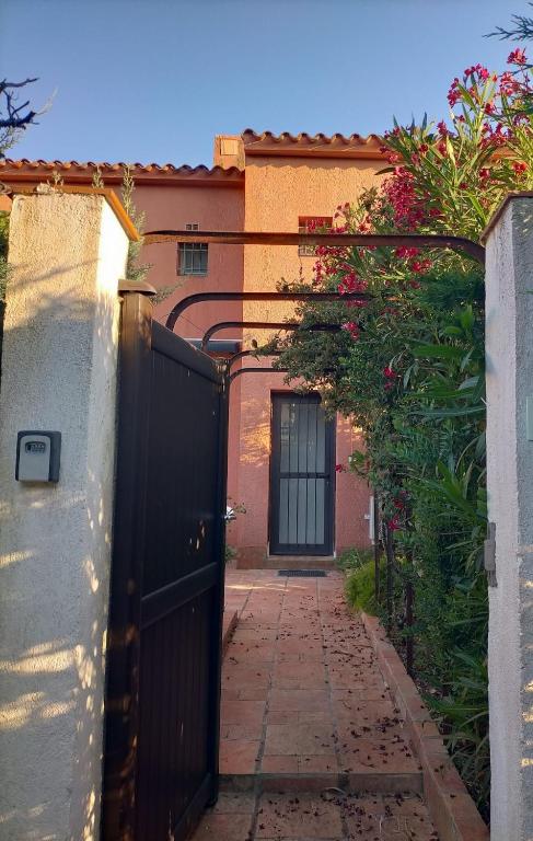 une entrée à une maison avec une porte noire dans l'établissement Appartement en bord de mer, à La Londe-les-Maures