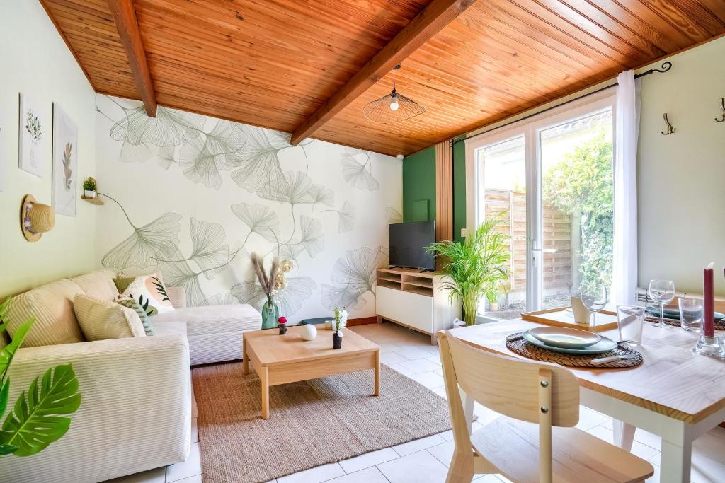 un salon avec un canapé et une table dans l'établissement Charmante maison indépendante avec terrasse verdoyante au calme absolu aux portes de Paris, à Houilles