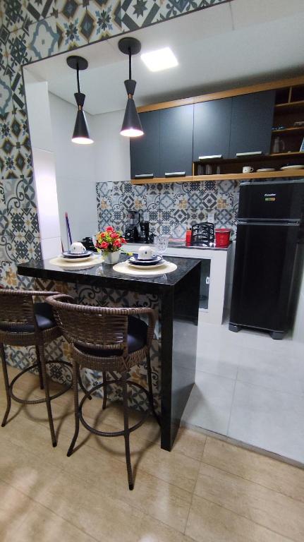 une cuisine avec une table et des chaises dans une cuisine dans l'établissement Seu refúgio no coração da cidade, à Paulo Afonso