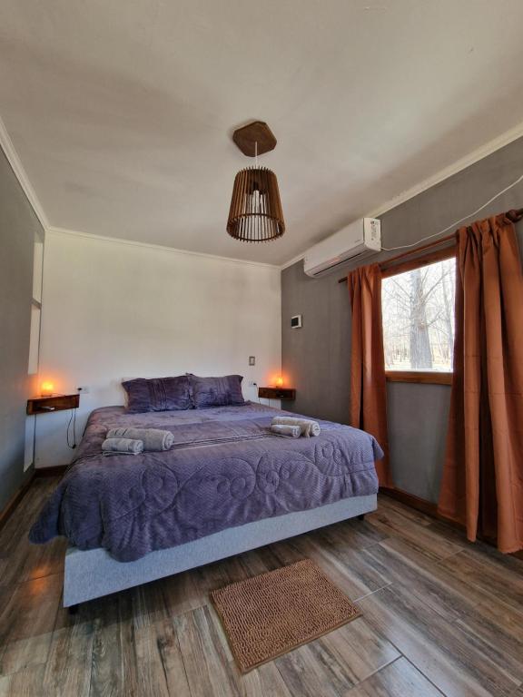 a bedroom with a large bed and a window at Cabaña Lumen in Uspallata