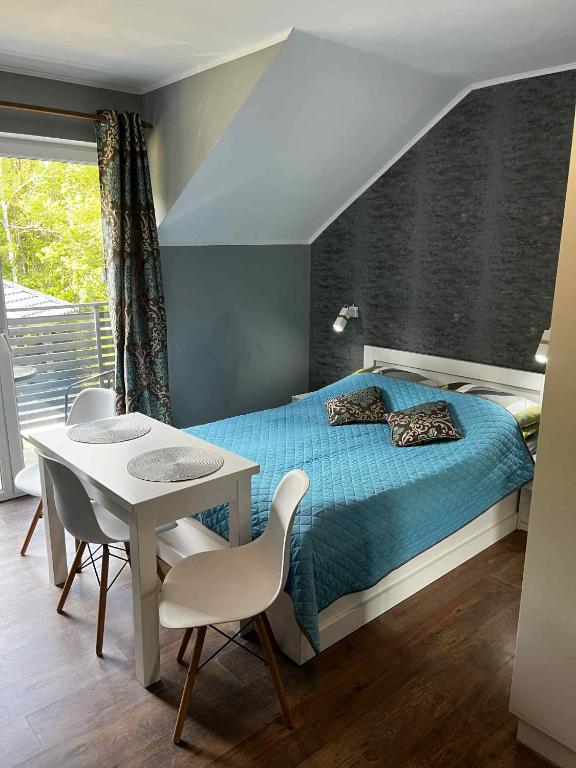a bedroom with a bed and a table and chairs at Pokoje Gościnne Ontario Mieroszyno in Jastrzębia Góra