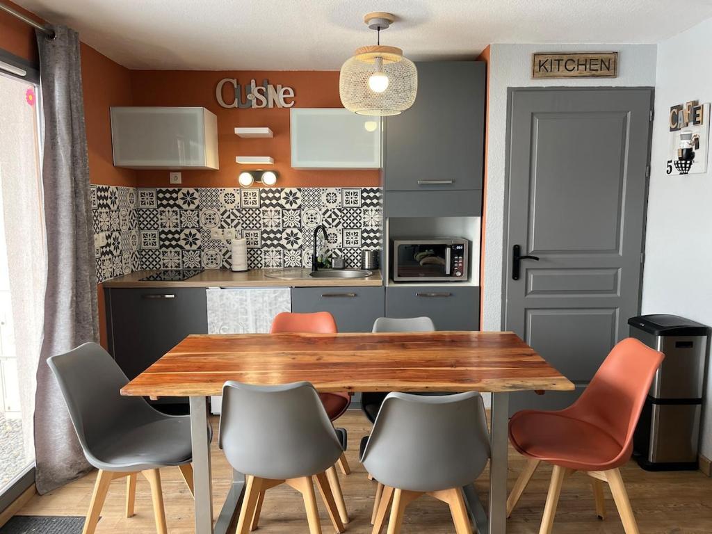une cuisine avec une table et des chaises en bois dans l'établissement Joue du Loup Apartement 6 personnes, à Saint-Étienne-en-Dévoluy