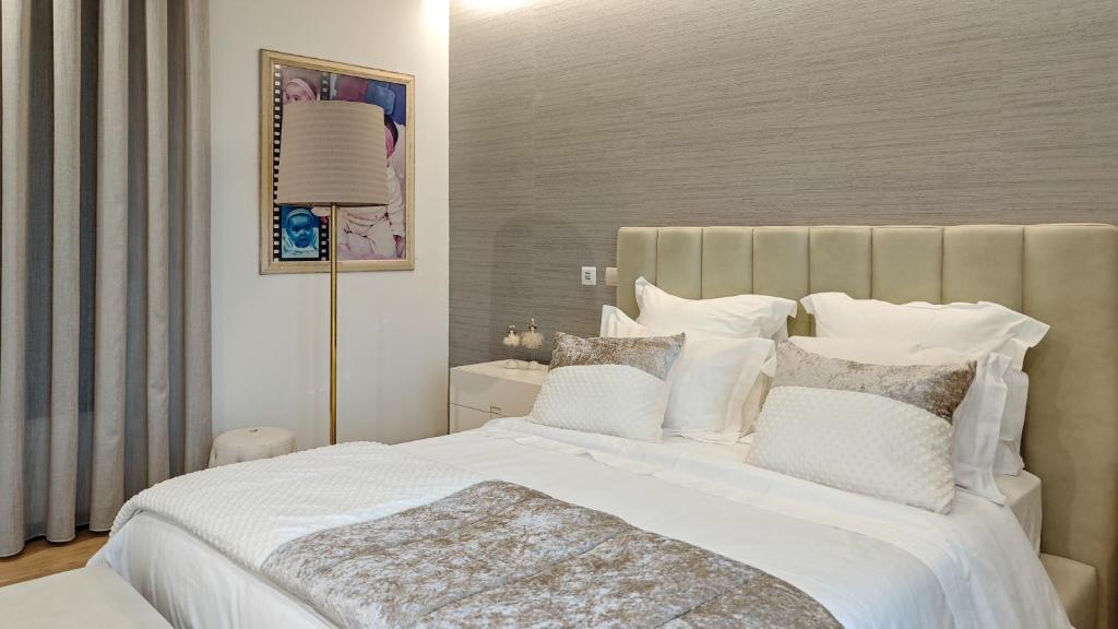a bedroom with a large white bed with white pillows at Royal Fraga do Douro in Vila Real
