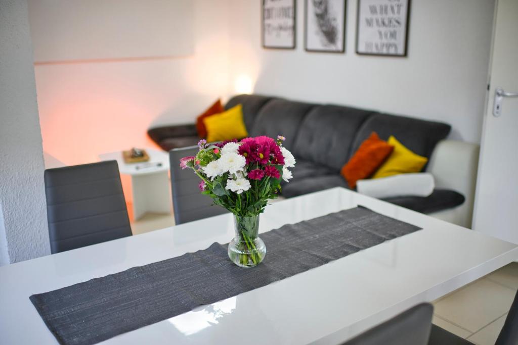 a vase of flowers on a table in a living room at Ferienwohnung NiSi in Münsingen