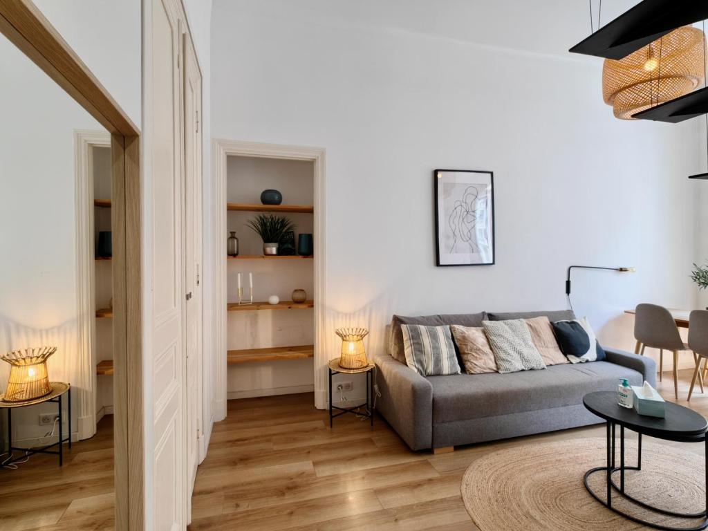 un salon avec un canapé et une table dans l'établissement Le Rossini by Bookking Guys, à Nice