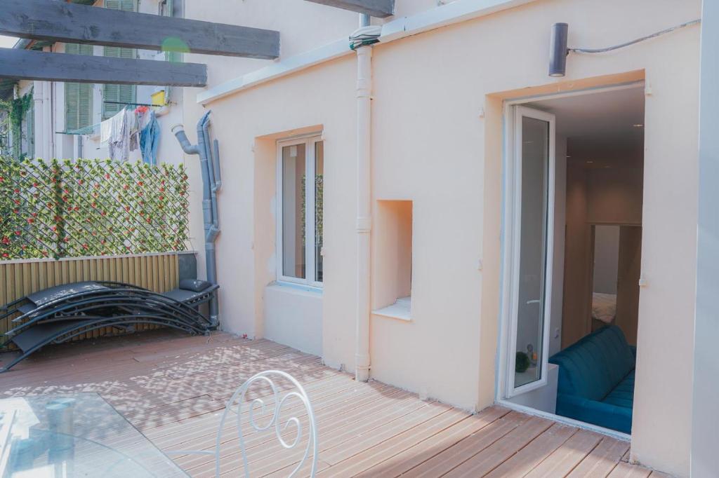 un patio avec un banc à côté d'un bâtiment dans l'établissement Cozy Home Cannes, à Cannes