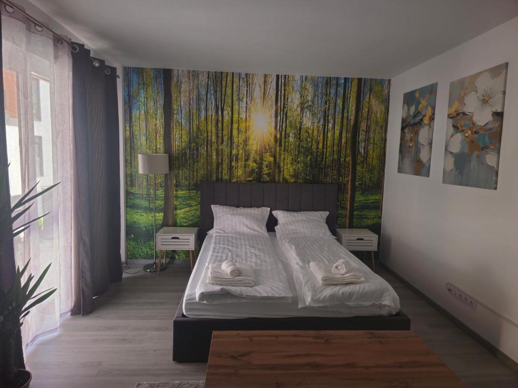 a bedroom with a bed with a painting on the wall at Central Urban Studio with Underground Parking in Târgu-Mureş