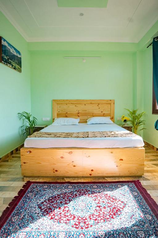 a large wooden bed in a bedroom with a rug at Riddhi Homestays Dharampur in Dharampur