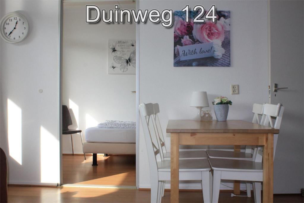 comedor con mesa, mesa y sillas en Appartementen Zuiderstrand H, en Westkapelle