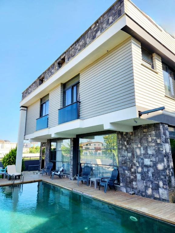 a house with a swimming pool in front of it at OLDSKOOL TOWN HOUSES 15 minutes walk to LARA beach in Lara