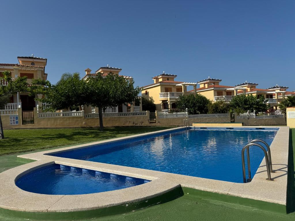 a large swimming pool in front of some apartments at Los Alamos Somhome in Peniscola