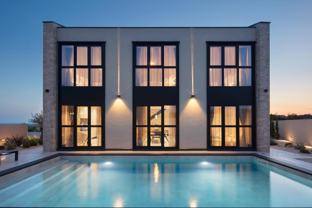 a swimming pool in front of a house at Casa Olivetta in Visočane
