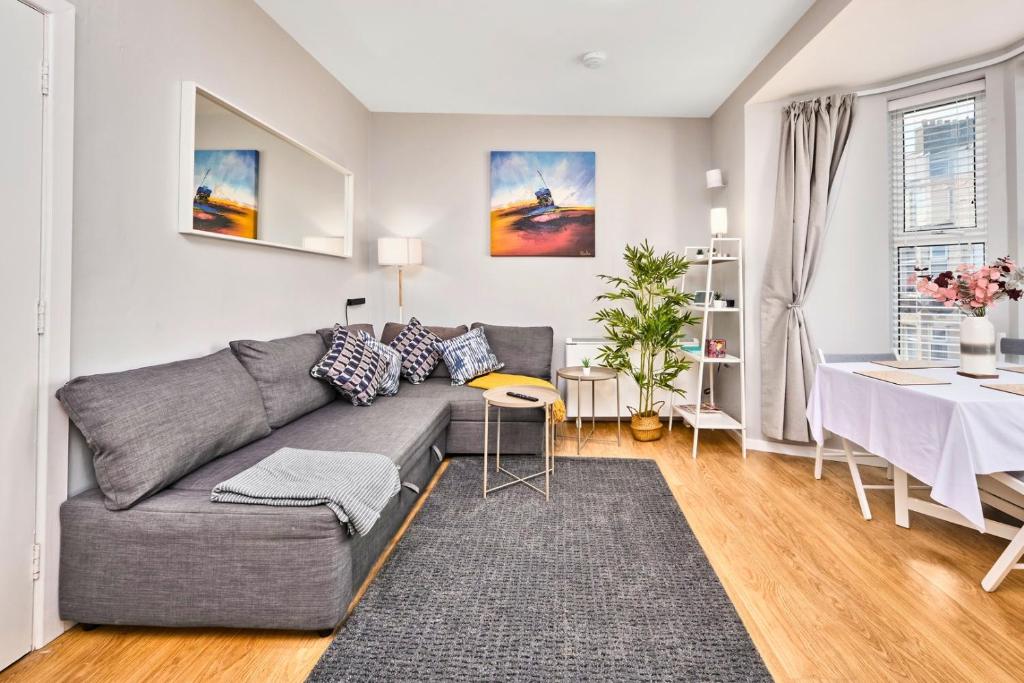 ein Wohnzimmer mit einer grauen Couch und einem Tisch in der Unterkunft Princess Blue 2 ~ Portrush by the Sea in Portrush