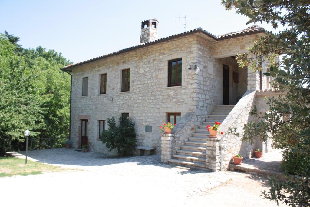 a large stone house with stairs in front of it at Il Vallone di Melezzole in Melezzole