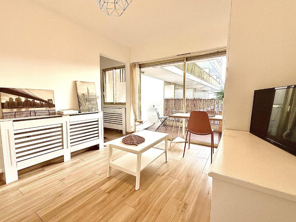 un salon avec une télévision et une table dans l'établissement Studio cosy a juan les pins, à Antibes