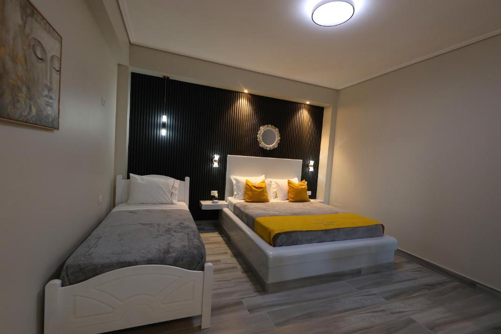 a bedroom with two beds with yellow pillows at Guest House Narta in Vlorë