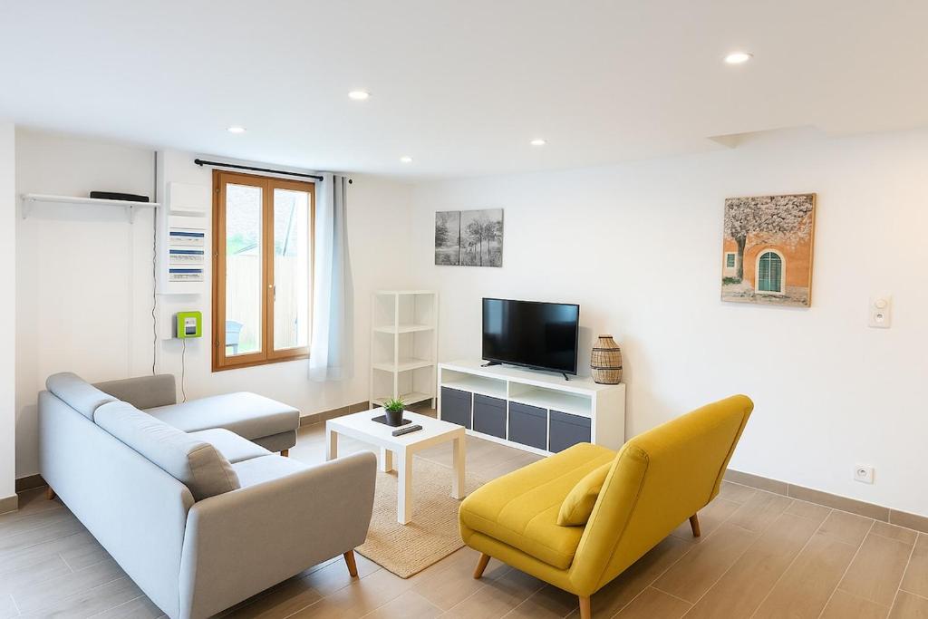 un salon avec un canapé et une télévision dans l'établissement Maison proche plages, climatisée, piscine, à Argelès-sur-Mer